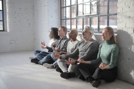 work self care: diverse group of colleagues having meditation together
